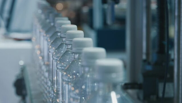 Water plastic bottles with caps transported by conveyor belt