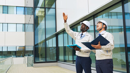 Group of multinational engineers inspecting a building © metamorworks