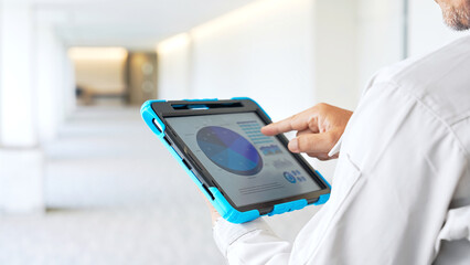 Engineer checking a building while looking at a tablet