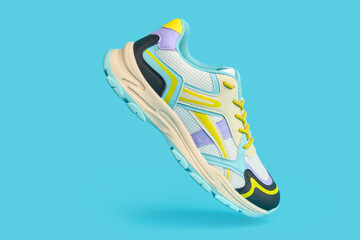White sneaker with colored accents on blue background, Fashionable sport shoe with colorful backdrop. Studio shot of shoes for shop advertisement, creative minimalist style