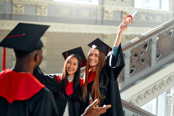 Diverse group of graduates celebrating their graduation day, joyful and proud in caps and gowns