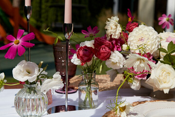 Elegant table setting with variety of fresh flowers and dishware. Content related to event planning...