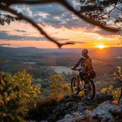 Naklejka premium Mountain Biker Pauses to Enjoy Stunning Sunset Panorama from Scenic Overlook
