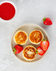 Cheesecakes with berries, sweet sauce, cashew and tofu. Healthy, vegan breakfast. Syrniki, cheese pancakes. Sugar, lactose and gluten free. Top view.