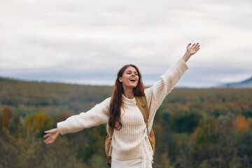 Mountain Adventure: Smiling Woman Embracing Nature's Freedom on Cliff