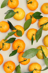 Top view juicy orange yellow tangerines with green leaf, Natural citrus fruit pattern minimal style, light  beige background. Organic, healthy, vegetarian and plant-based food concept, pastel tones