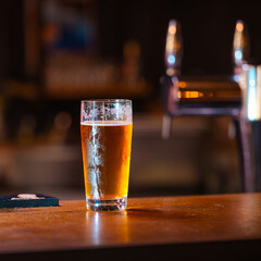 Photographie d'un verre de bière servi sur un bar 