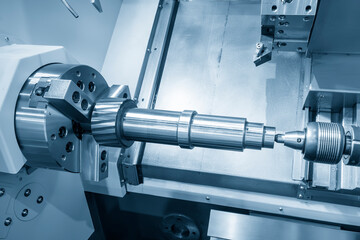 The  CNC lathe machine forming  cutting the metal shaft parts.