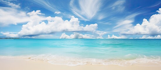 Obraz premium Beautiful beach with white sand turquoise ocean water and blue sky with clouds in sunny day Panoramic view Natural background for summer vacation. Creative banner. Copyspace image