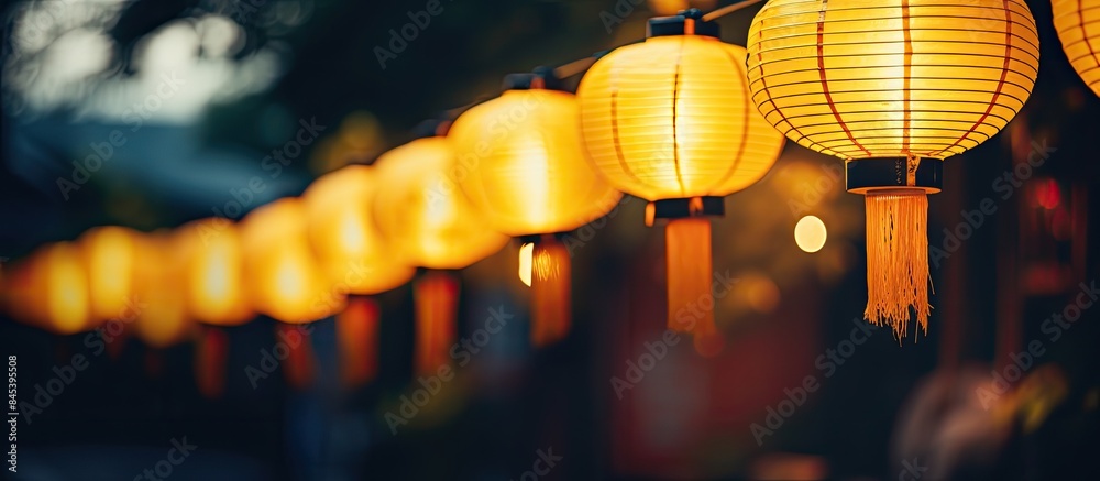 Aufkleber a row of yellow lanterns at night against a blurred background the subject is out of focus. creative