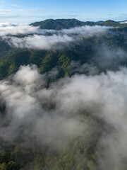 A high-angle landscape, dense fog, natural forest mountains covered in fog. A bright sky and beautiful landscape can be viewed from the sky with a drone.