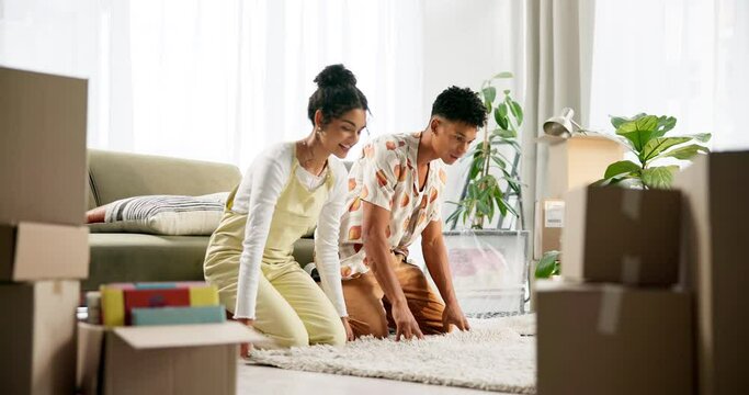Apartment, teamwork and couple rolling a carpet on floor in new home, house or living room. Smile, property furniture and man with woman moving in real estate with boxes, rug and excited unpacking