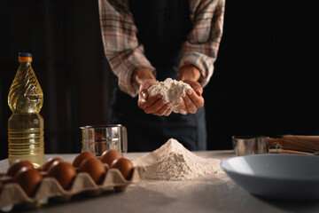 Engaging in the process of adding flour to the mixture as part of the preparation for baking
