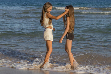 Portrait of Twin Sisters with Blonde Hair and Green Eyes, Reveling in Their Vacation Joy While...