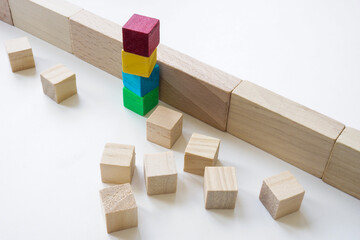 Colored cubes overcome an obstacle as a concept of teamwork, collaboration and unity.