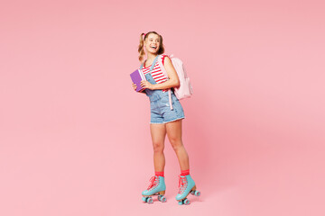 Young smiling girl student wear casual clothes backpack bag rollers rollerblading hold books look...