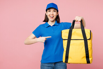 Professional delivery girl employee woman wearing blue cap t-shirt uniform workwear work as dealer courier point on yellow thermal food bag backpack isolated on plain pink background. Service concept.
