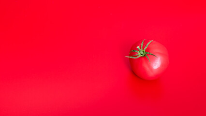 Red tomato on a red background with a place for text