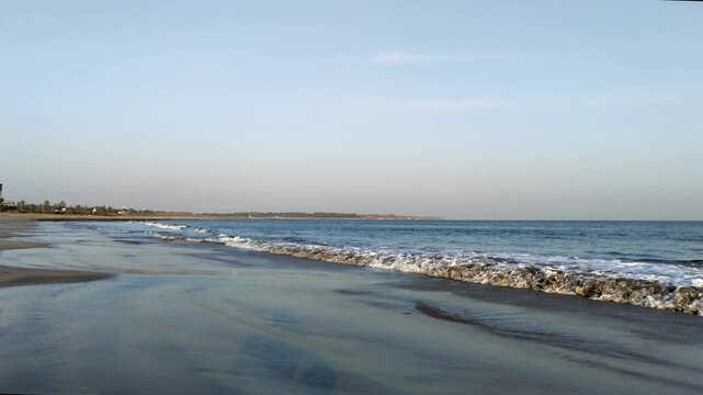 Slow motion of small waves of the sea arrive creating white foam on sand, on a clear day, Waves coming to the beach Shore, Full HD