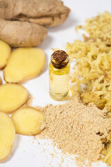 Natural ginger oil in glass bottle among ginger roots
