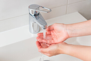 Sustainable use of natural resources banner. Clean tap water concept. Woman's hands with water near flow tap. Water running from chrome faucet. Using water resources concept, environmental protection