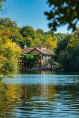 Obraz premium Small Buildings in France Across Forest with Calm Water on Sunny Day