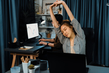 Businesswoman working on desk with stretching arm up and down manner with body health ache of...