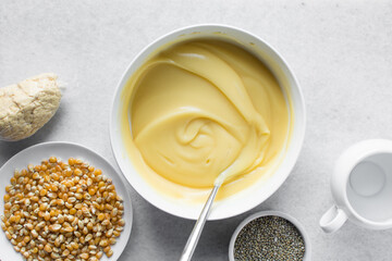 Overhead view of nigerian akamu in a white bowl, pap akamu or ogi in a white bowl, top view of nigerian corn pudding in a white ramekin