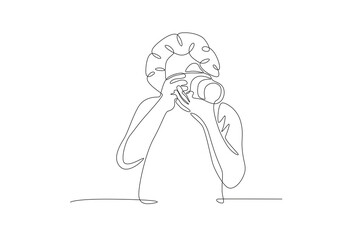 Curly guy taking photos. World photography day concept one-line drawing