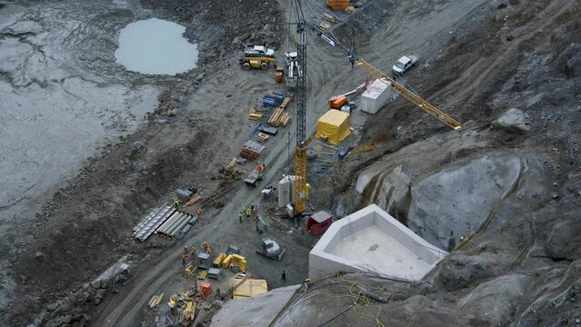 Intense construction work on a mountain water reservoir featuring extensive tunnel work and heavy industry equipment, ideal for projects showcasing engineering, infrastructure, and industrial themes