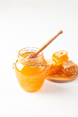 Honey dripping from a wooden honey dipper on white background. Healthy organic food concept. 