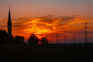 Fototapeta premium Sunset with a church silhouette near Wallerdorf, Künzing, Deggendorf, Bavaria, Germany