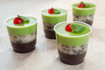 puding lapis alpukat or avocado layer pudding. topped with cherry pieces and mint leaves. Very fresh and healthy