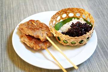 Grilled pork sticks and Sticky rice on table.