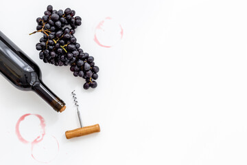 Bottle of wine with corkscrew and grapes. Wine background