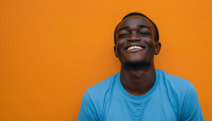 Obraz premium A smiling man in a blue shirt is standing in front of a yellow wall