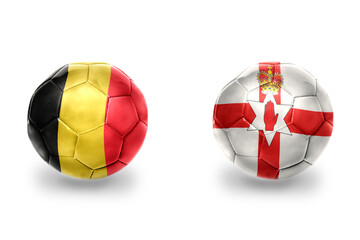 Obraz premium football balls with national flags of northern ireland and belgium ,soccer teams. on the white background.