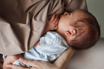 Home breastfeeding routine. Home lactation support. Comfortable nursing space. Unrecognizable woman...