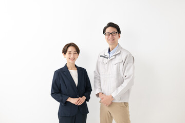 スーツ姿の女性と作業着姿の男性