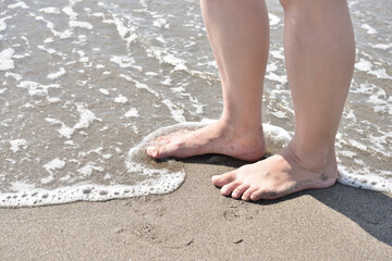 打ち寄せる波と女性の足