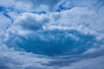 Blue cloud vortex in sky, close-up, hurricane formation, cloud funnel
