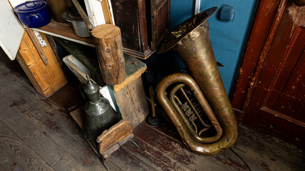 An antique brass tuba and vintage items are displayed in a charming rustic wooden room