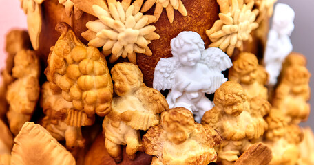 Christmas composition with a figurine of an angel made of sugar on a large pie, surrounded by angels made of dough, close-up.