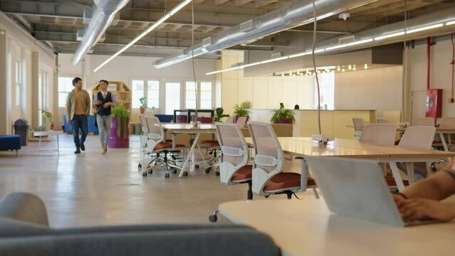 Wide Angle of Brazilian team of business people walking and talking in office workspace.&nbsp;&nbsp;