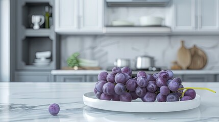A handful of purple grapes on a clean white plate, with a modern kitchen setting in the background.