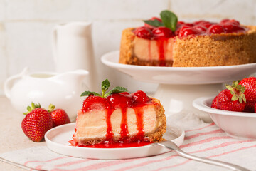 Slice of Classic baked Cheesecake  with a strawberry topping sauce. Homemade dessert. White background.