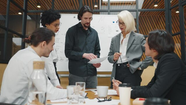 Group of multiethnic businesspeople discussing new project in office, teamwork. Woman boss speaking to employees and specialists about company strategies and business idea, creative marketing team