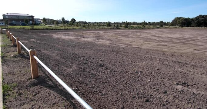 A large plot of vacant land near a suburban residential neighborhood awaits real estate development. This concept captures the potential for land sales, construction site preparation, and future homes