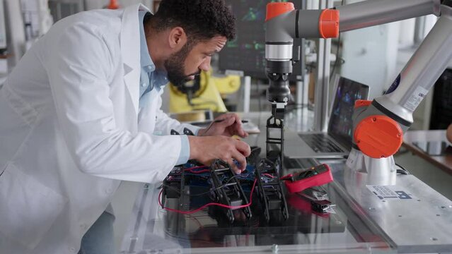 Robotic engineer working on mechanical system of robotic arm, electrical engineering. Concept of robotics, engineering and computer science.