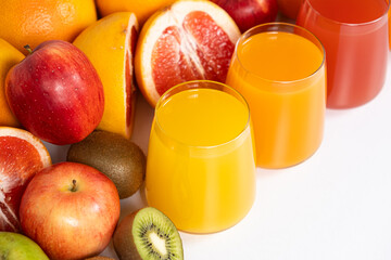 Different fruit juices in glasses on white background